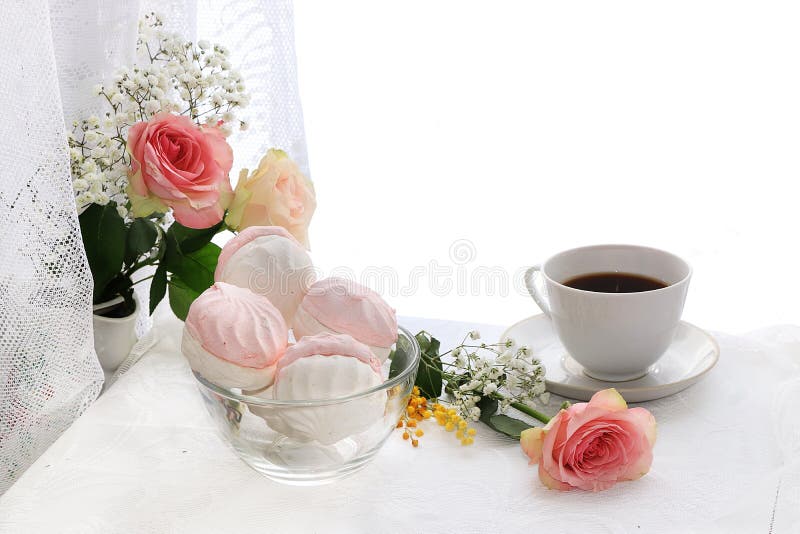 Ένα φλιτζάνι του καφέ και λουλούδια σε ένα ελαφρύ υπόβαθρο, επιθυμίες της καλημέρας και της καλημέρας